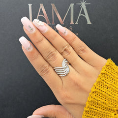 Hand with pink nail polish and a diamond wave ring.